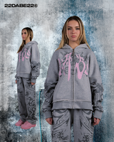 Grey/Pink Split Zip Jacket from 22DABE22: A long sleeve hooded zip jacket with a unique split design in grey and pink. Front features screen print and embroidery appliqué, with screen print on sleeves. Special feature zipper at the back allows for reversible wear. Made from 80% cotton and 20% polyester, weighing 500 GSM. Soft peached finish on the inside, with a distressed finish for edginess.