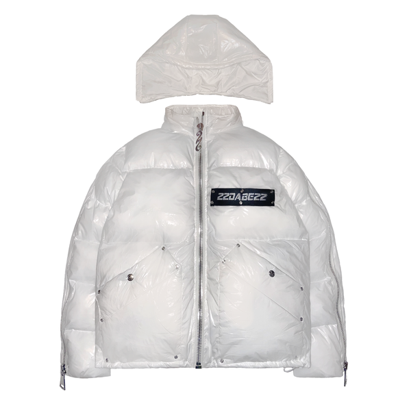 A white puffer jacket from 22DABE22, made of high-quality nylon fabric and cotton down filling, featuring custom logo rivets and buttons, detachable hood, and adjustable drawcords on the bottom hem. The jacket has an oversized fit, with sleeves that can be unzipped for unrestricted movement and ample storage space with one inside pocket and two side pockets. The logo tape at the chest adds a touch of branding.