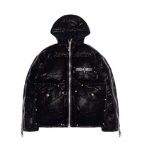 A black puffer jacket with a detachable hood, designed for streetwear enthusiasts. The jacket is made of 100% nylon shell and has 100% cotton down filling for warmth. It features custom DABE logo rivets and buttons, metallic hardware, and 22 custom pullers for added style. Both sleeves can be zipped for arm movement and there is a logo tape at the chest.