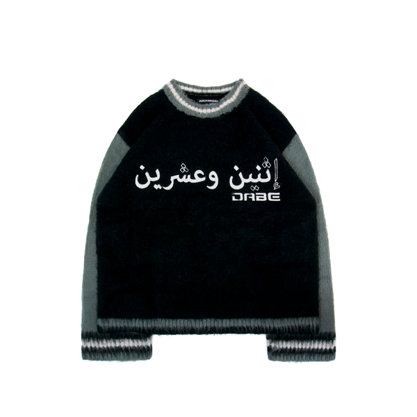 A grey oversized sweater with flared sleeves and unique embroidery on the front. The sweater has a distinct Mohair Style texture and is made of 100% Acrylic material using a double layer knitting technique. The sweater is unisex and offers versatility for all genders, making it perfect for layering over streetwear outfits.