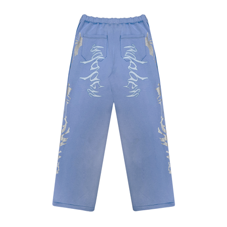 A pair of light blue joggers with glitter screen print on both sides, an embroidery appliqué at the back pockets, and a distressed finish. Made of 80% Cotton and 20% Polyester blend with a peached interior for ultimate comfort and durability. Oversized fit and perfect for streetwear collection.