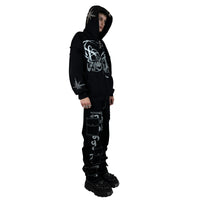 A black long sleeve hooded zip jacket with a unique split design featuring rhinestones and screenprint detailing at the front. The jacket has an oversized fit, big hood, and a distressed finish for a vintage feel. Made from 80% cotton and 20% polyester with a peached interior, it has a custom 22 puller and logo embroidery on the pocket.