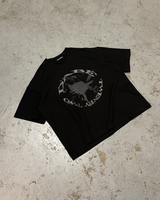 A black oversized t-shirt with a glitter screenprint on the front, made from 100% cotton with a distressed finish. The shirt is unisex and has a high-quality screenprint that stays vibrant after washing. The shirt is versatile and can be paired with jeans, joggers, or shorts.